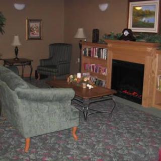 A cozy living room with a sofa, fireplace, and bookshelf.