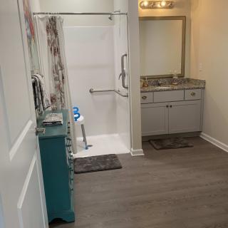 A modern bathroom with a walk-in shower and vanity sink.