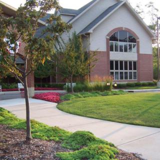A modern building with a well-maintained lawn and landscaped garden.