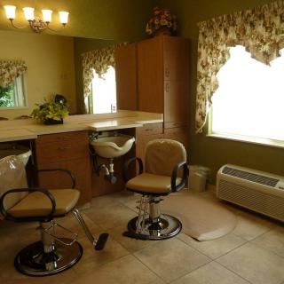 A cozy salon interior with chairs and a vanity mirror.