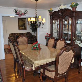 A traditional dining room with a wooden table, chairs, and a chandelier.