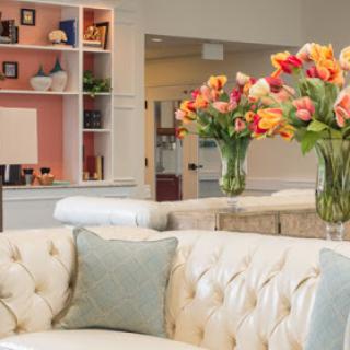 A beautifully designed living room featuring a plush sofa and vibrant flower arrangements.
