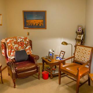 A cozy living room corner with two armchairs, a side table, and a warm light.