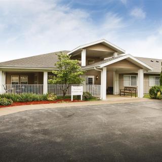 A single-story building with a driveway and surrounding landscape.