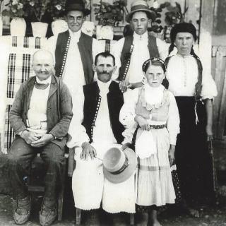 A vintage black and white family photo featuring individuals in traditional clothing.
