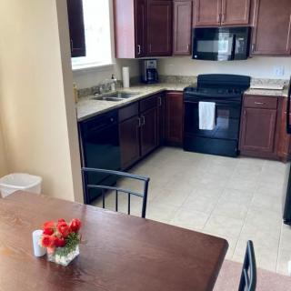A modern kitchen with wood cabinets and a dining table adorned with flowers.