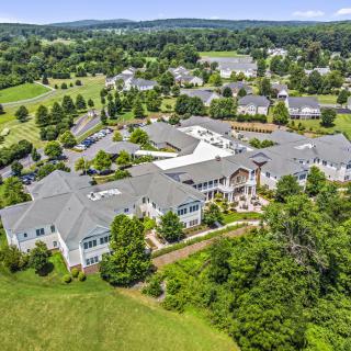 Aerial view of a large residential complex surrounded by lush greenery and well-maintained landscaping.