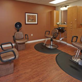 A modern and inviting hair salon interior featuring comfortable styling chairs and a cozy atmosphere.