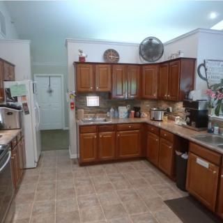 A spacious kitchen with wooden cabinets and modern appliances.