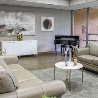 A stylish modern living room featuring comfortable seating, elegant decor, and a piano.