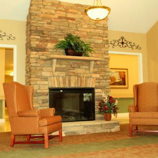 A cozy living room featuring a stone fireplace and comfortable seating.
