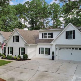 A suburban house with a spacious driveway and a well-maintained lawn.