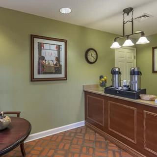 A cozy lobby area with a coffee station, artwork, and soft lighting.