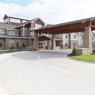 A modern facility with a covered entrance and landscaped driveway.