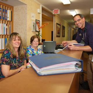A friendly reception area with staff assisting at the front desk.