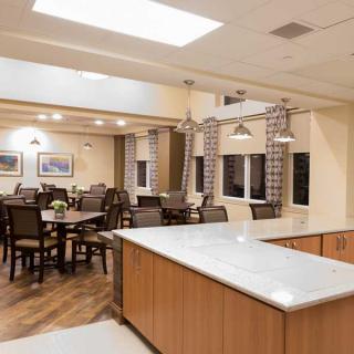 A modern dining area with a kitchen island and stylish lighting.