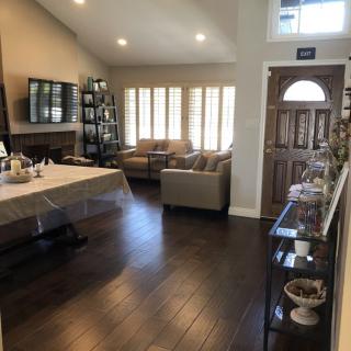 A cozy living room with a dining table, sofa, and hardwood floors.