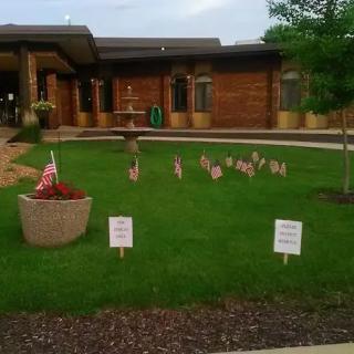 A building with a lawn decorated with small flags and signs.