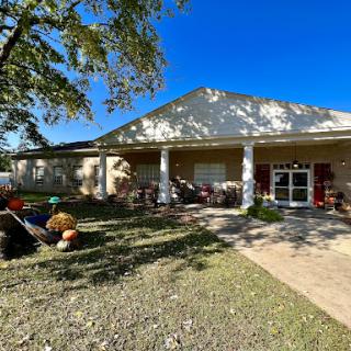 A charming house with a well-maintained garden and a clear blue sky above.
