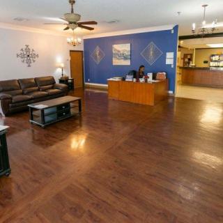 A spacious and well-lit reception area with a wooden desk, a comfortable sofa, and elegant decor.