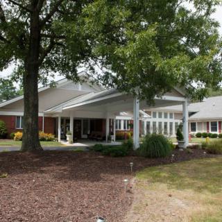 A building with a tree-lined entrance and landscaped surroundings.