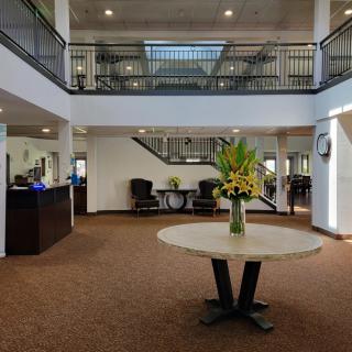 A spacious hotel lobby with a round table centerpiece and elegant interior design.