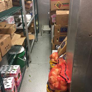 A storage room filled with boxes and bags of food items, including apples.