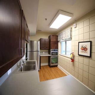 A modern kitchen with dark wood cabinets and stainless steel appliances.