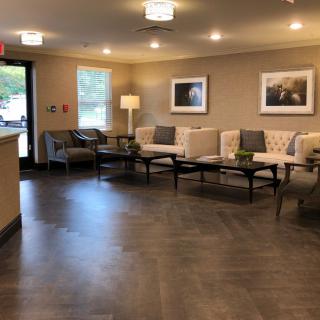 A modern waiting room with neutral colors and comfortable seating.