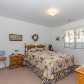 A cozy bedroom with floral bedding and wooden furniture.