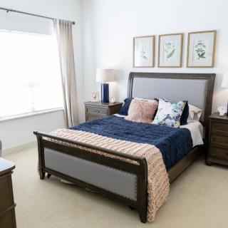A modern bedroom with a sleek bed, nightstands, and decorative artwork on the walls.