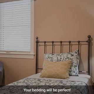 A neatly made bed with patterned pillows in a cozy bedroom setting.