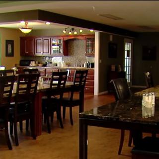 A spacious kitchen and dining area featuring wooden cabinets and a large dining table with bar stools.