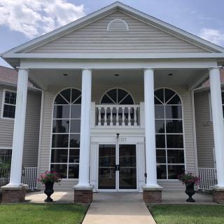 A symmetrical building with large columns and windows at the entrance.