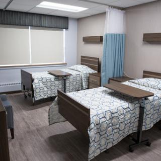 A modern patient room in a hospital featuring two beds and a clean, organized space.