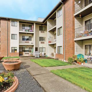 A three-story apartment building with a well-maintained courtyard and balconies.