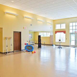 A spacious and bright dance studio with large mirrors and fitness equipment.