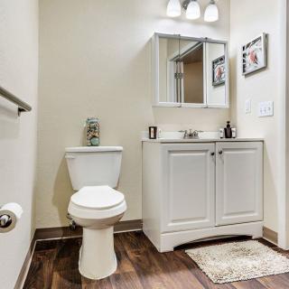 A well-organized bathroom with a toilet, vanity sink, and mirrored cabinet.