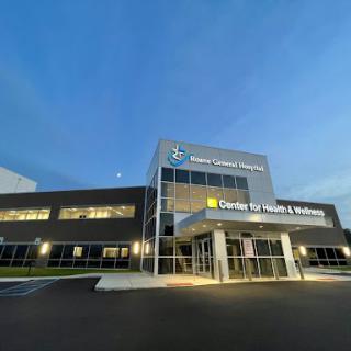 A modern healthcare facility photographed during the evening, showcasing its sleek architectural design.
