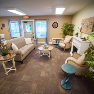 A cozy living room with comfortable seating, a fireplace, and decorative elements.
