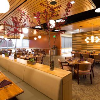 A modern restaurant interior with elegant wooden decor and warm lighting.