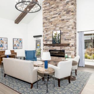 A modern living room with a stone fireplace and stylish furnishings.
