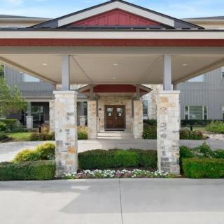 A building entrance with stone pillars and a landscaped pathway.