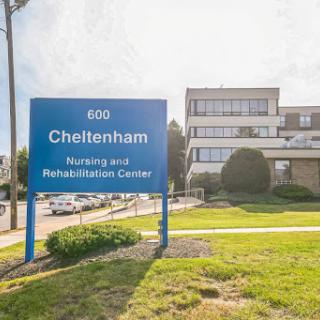 A view of the Cheltenham Rehabilitation Center building with a clear sign displaying its name and address.