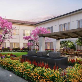A beautifully landscaped courtyard with colorful flowers and elegant architecture.