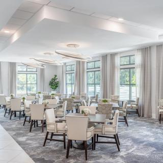 A modern dining room with elegant furniture and large windows.