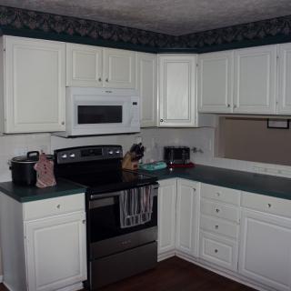 A home kitchen featuring white cabinets and modern appliances.
