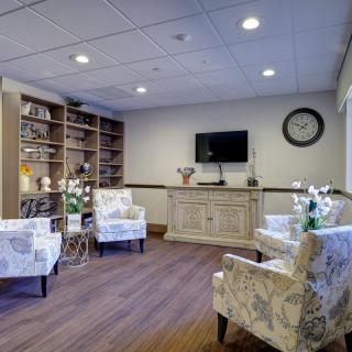 Cozy waiting room with comfortable seating and a wall-mounted television.