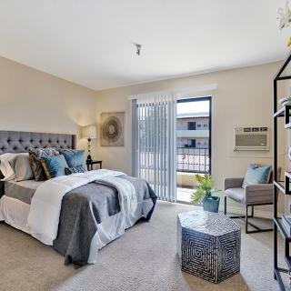 A modern and elegantly decorated bedroom with natural light streaming through the window.