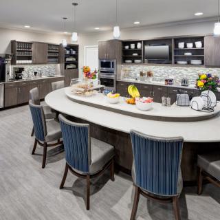 A modern kitchen with a spacious island, equipped with appliances and stylish seating.